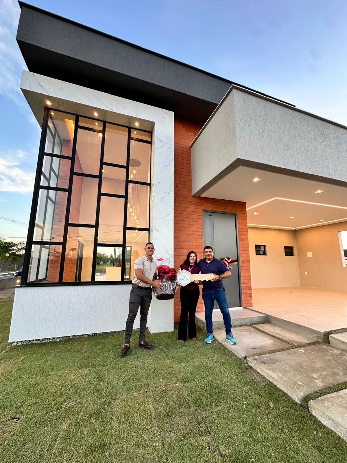Família recebendo as chaves da casa entregue pela Fraga